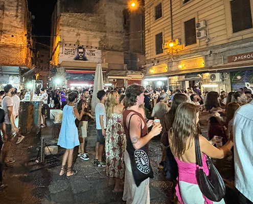 people dancing in vucciria market at night, drinking and pubs